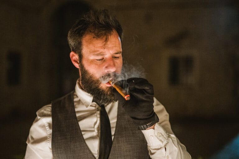Artistic shot of the waiter smoking a cigar