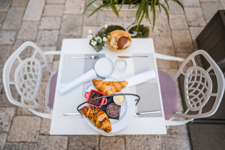 Three-tier breakfast stand with pastries, fresh fruit, cheeses and cured meats.
